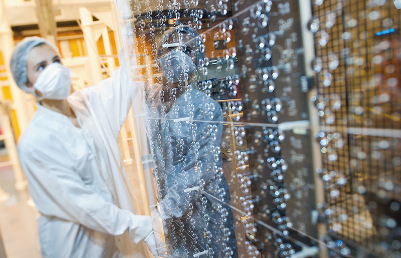 Scientist in a lab holding a glass panel